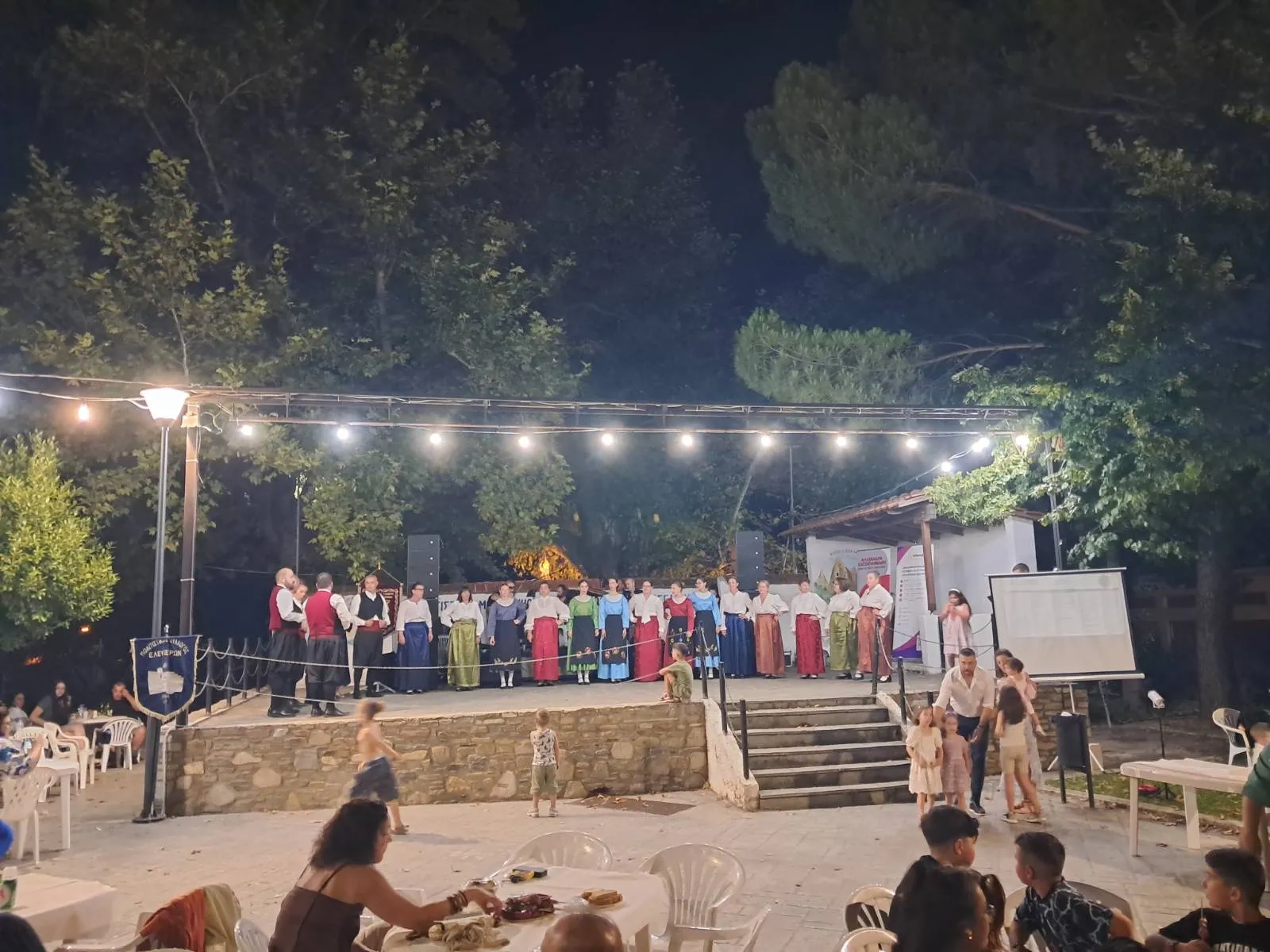 Μέλη χορευτικού συλλόγου σε παράταξη στη σκηνή της πλατείας