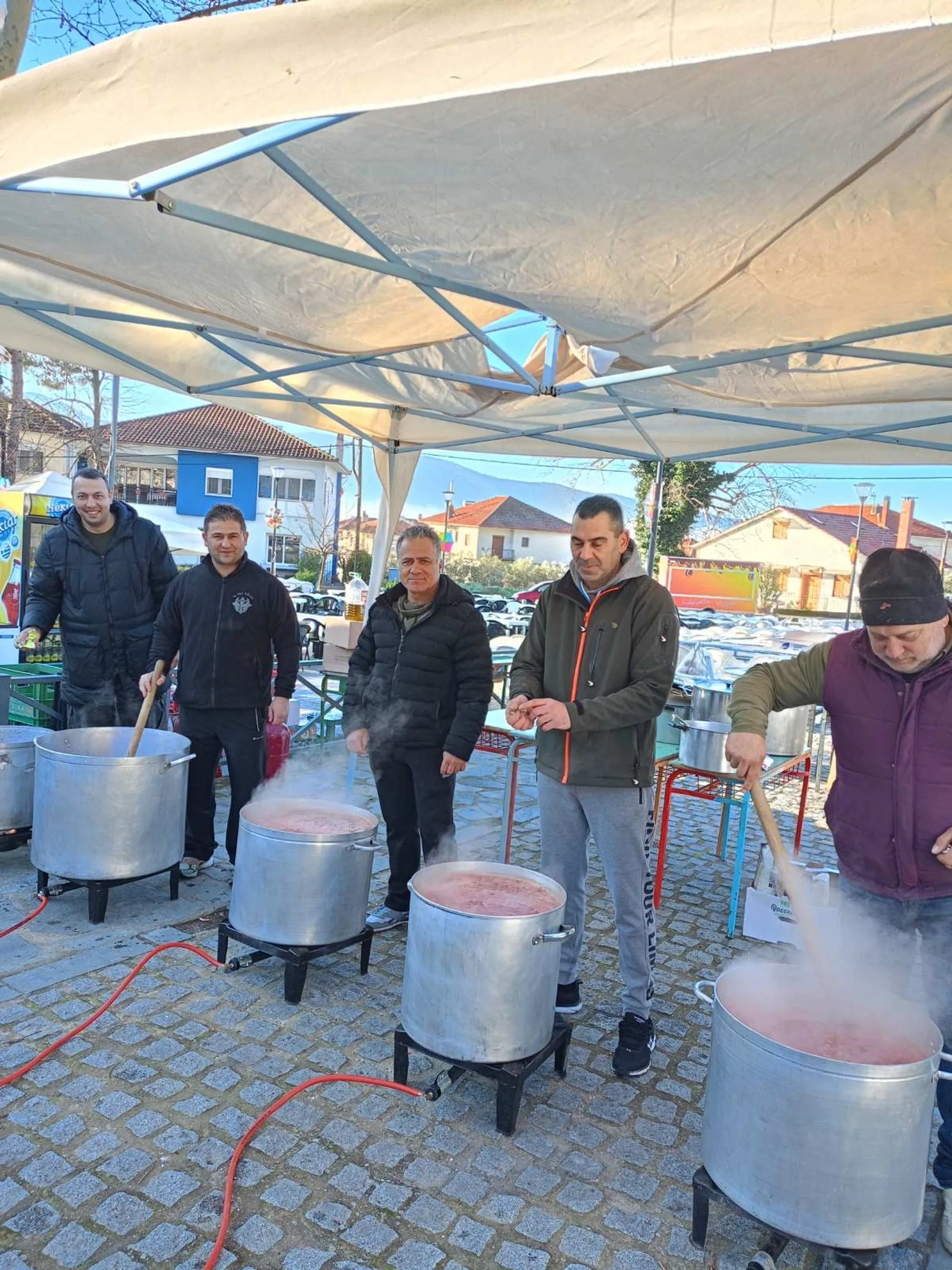 Μέλη του συλλόγου ανακατεύουν φασολάδα σε μεγάλα καζάνια στην πλατεία Δωματίων